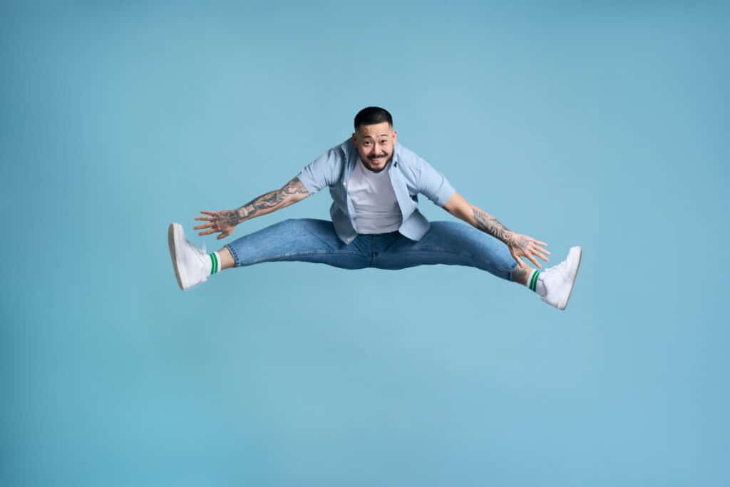 full-length-of-crazy-overjoyed-asian-man-jumping-i-2023-11-27-05-15-10-utc